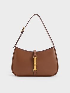 This product is made with at least 20% sustainable materials by weight. CHARLES & KEITH uses recycled, degradable, organic, and water-based materials in our eco-conscious collection. The Cesia minimalist design enhances its versatility, making it the perfect style companion for office hours, casual weekends, and everything in between. With its timeless combination of chocolate brown and metallic gold, it will add a touch of elegance to your everyday wardrobe, effortlessly elevating any look. The metallic gold accent serves not only as a decorative element but also as a functional magnetic closure, ensuring the safety and security of your personal belongings. Handbags Charles And Keith, Purse Dump, It Girl Bag, Charles And Keith Bags, Charles And Keith, Neutral Bag, Dream Bags, Brown Purse, Personal Belongings