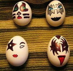 three eggs with faces painted on them sitting in front of a sign that says happy easter