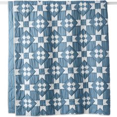 a blue and white quilt hanging on a wall