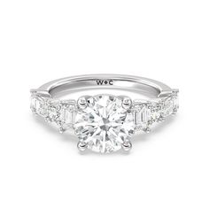 a white gold engagement ring with three baguets on the band and side stones