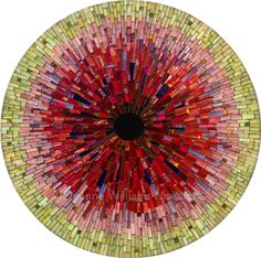 a circular glass plate with multicolored tiles in the shape of a sunburst