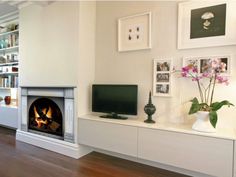 a living room filled with furniture and a fire place in front of a flat screen tv