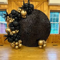 a chocolate cake with black and gold decorations on it's side in front of a wood paneled wall