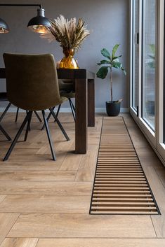 a dining room table with chairs and a potted plant on the floor next to it