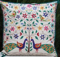 a decorative pillow with two peacocks on it