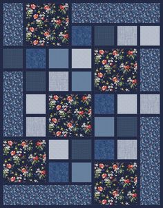 a blue and white patchwork quilt with flowers on the front, one block in the middle