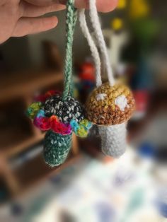 two small crocheted mushrooms hanging from strings