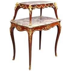 three tiered table with marble top and gold trimmings on the sides,