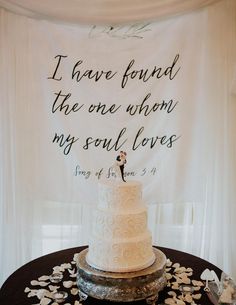 a white wedding cake sitting on top of a table next to a sign that says i have found the one when my soul loves