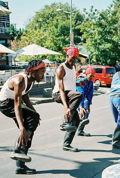 some people are doing tricks on their skateboards in the street while others look on