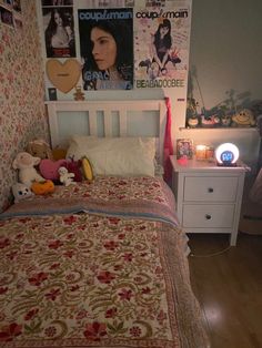 a bedroom with a bed, night stand and pictures on the wall above it's headboard