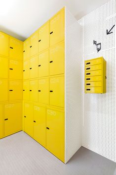 there is a yellow lockers in the room with white walls and drawers on it