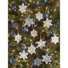 a christmas tree decorated with white crocheted snowflakes and blue baubles