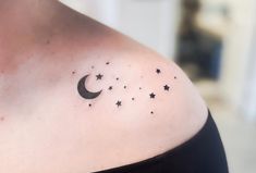 a woman's shoulder with stars and a crescent tattoo