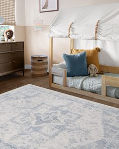 a child's bedroom with a bed, dresser and toy animal on the floor