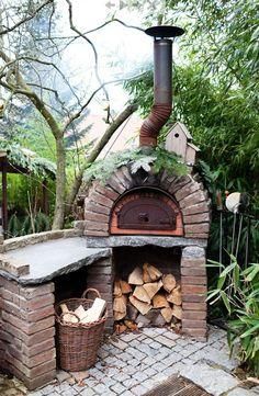 an outdoor brick pizza oven with logs in it