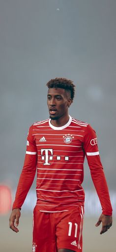 a man in red and white soccer uniform holding a ball