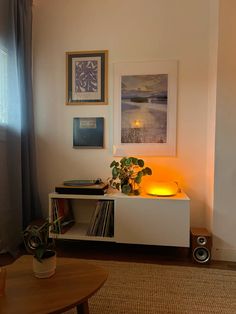 a living room with an entertainment center and bookshelf in front of a window