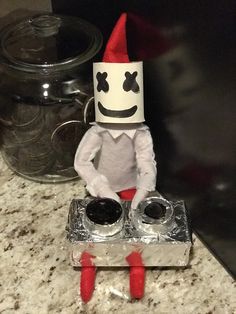 an elf is sitting on top of a stove with two burners in front of him