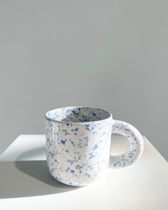 a blue and white cup sitting on top of a table