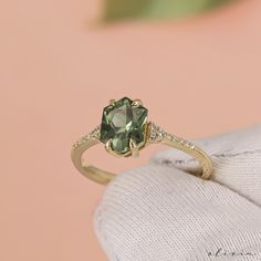 a close up of a ring with a green and white stone in it's center