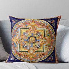 a decorative throw pillow with an intricate design on the front and back side, sitting on a couch