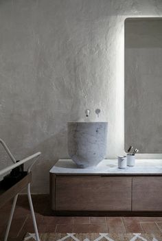 a bathroom with a large mirror, sink and bathtub next to a white chair