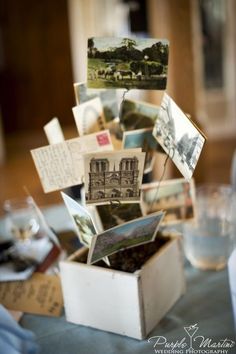 a table topped with lots of pictures and postcards on top of a wooden box