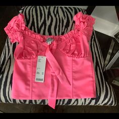 a pink top with ruffles on it sitting on a zebra print chair