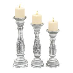 three silver candlesticks with one lit and the other turned off in different directions