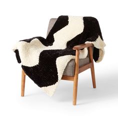 a black and white blanket sitting on top of a chair next to a wooden frame