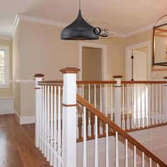 an empty house with wood floors and white railings