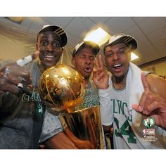 three basketball players posing for a photo with the trophy in front of their heads and hands