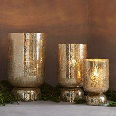 three gold vases sitting next to each other