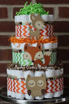 a three tiered diaper cake with woodland animals on the top and chevron paper