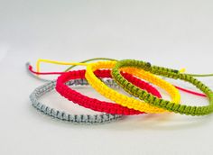 four different colored bracelets sitting on top of each other