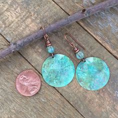 Blue green patina and hammered copper earrings with Czech glass accents.Hand-forged, domed copper discs with an earthy, rustic green-blue patina finish and a textured, rustic Czech glass bead.As I apply the patina finish to each pair individually, there may be some variation in the finish color pattern, however each pair will be equally beautiful and unique! You may request a more blue or green finish in the comment section at checkout.Product overview:- Made with hammered copper discs, Czech gl Soldered Turquoise Brass Earrings, Turquoise Soldered Brass Earrings, Turquoise Artisan Electroformed Earrings, Artisan Drop Earrings With Patina, Adjustable Bohemian Patina Earrings, Hammered Copper Turquoise Jewelry, Turquoise Hammered Copper Jewelry, Green Patina Bohemian Earrings, Green Hammered Bohemian Jewelry