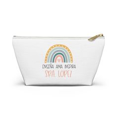 a white cosmetic bag with an image of a rainbow and the words, ensena ama