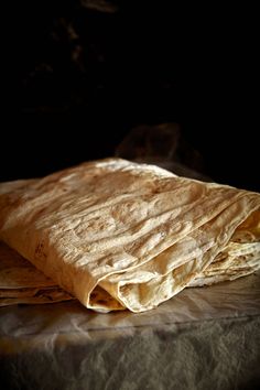 two tortilla wrappers sitting on top of each other next to a black background