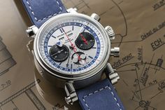 For this new limited edition, Speake-Marin pays tribute to one of the most loved chronograph models of the 20th century: the Valjoux 88 Calibre, which is often seen as the finest manually-wound chronograph ever, thanks to its column-wheel and its three counters. DIAMETER: 42 mm REFERENCES: 514208010 INDICATIONS: Hours and Minutes, Triple date, Chronograph, Moon phase DIAL Black counters Blue or beige indexes STRAP: Blue Nubuk leather POWER RESERVE: 44 hours WATER RESISTANCE: 3 bar (30 metres) LI Breitling Watch, Jaeger Watch, Chronograph, London, Blue, Leather, Black