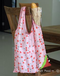 a pink bag sitting on top of a wooden chair next to a piece of bread