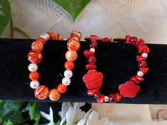 Orange beaded and red floral bead bracelets that stretch. Perfect for small to medium wrist. Acrylic beads with different shades beads with designs. perfect for younger girls Red Bracelets With Heart Beads, Adjustable Coral Stretch Bracelet As Gift, Casual Red Jewelry With Heart Beads, Bohemian Red Flower Bracelets, Red Bohemian Flower Beaded Bracelets, Red Flower-shaped Bohemian Beaded Bracelets, Bohemian Red Flower Beaded Bracelet, Red Flower-shaped Beads For Gifts, Red Bohemian Beaded Bracelets With Heart Beads