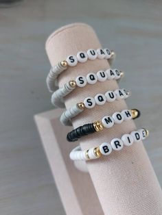 four bracelets with words on them sitting on a napkin holder