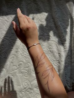 a woman's arm with a tattoo on it and her hand holding the wrist