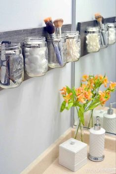 mason jars are hanging on the wall above a bathroom sink