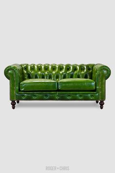 a green couch sitting on top of a white floor