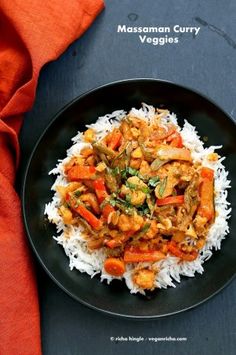 a black plate topped with rice and vegetables