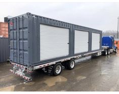 a semi truck with a large container on it's flatbed is parked in a lot