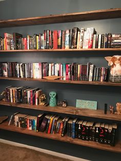 a bookshelf filled with lots of books on top of wooden shelves