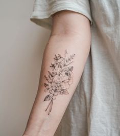 a woman's arm with a flower tattoo on the left side of her arm